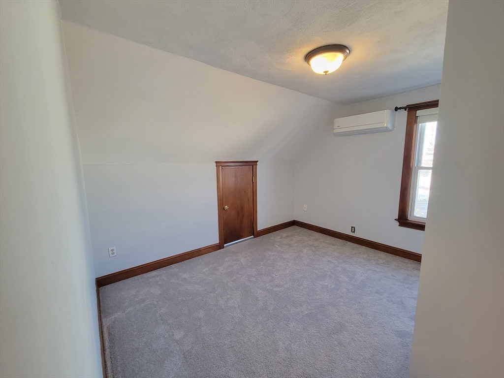 100 Medford Street, Unit 2 Malden, MA 02148 - Photo 26 of 29 a view of an empty room with a window and wooden floor