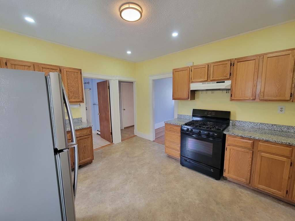 100 Medford Street, Unit 2 Malden, MA 02148 - Photo 4 of 29 a kitchen with stainless steel appliances granite countertop a stove a refrigerator and a sink