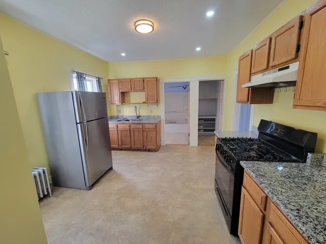 a kitchen with stainless steel appliances granite countertop a refrigerator stove and oven