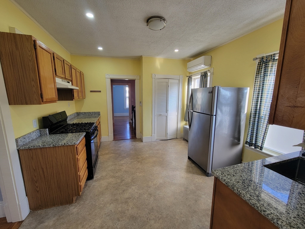 100 Medford Street, Unit 2 Malden, MA 02148 - Photo 6 of 29 a kitchen with stainless steel appliances granite countertop a refrigerator a stove and a sink