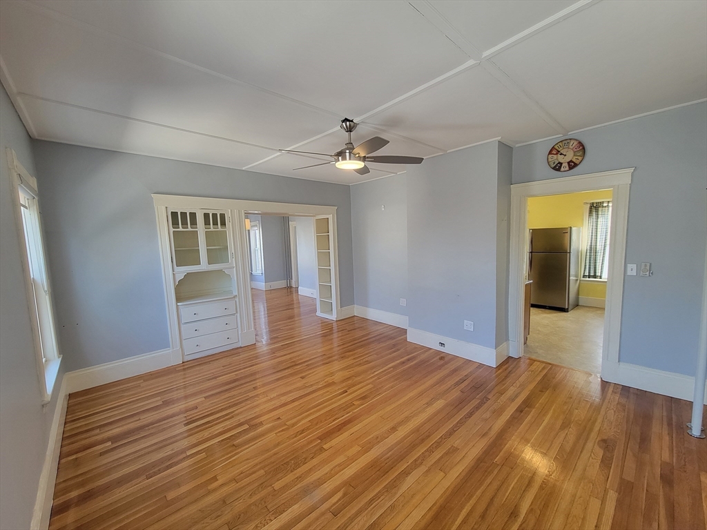 100 Medford Street, Unit 2 Malden, MA 02148 - Photo 8 of 29 a view of an empty room with wooden floor and a window