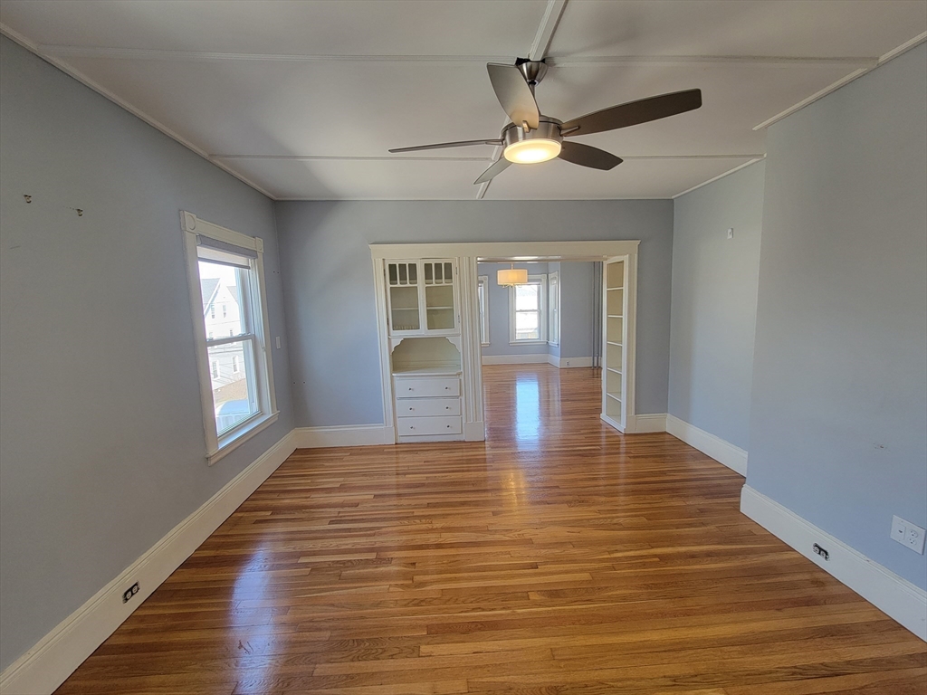 100 Medford Street, Unit 2 Malden, MA 02148 - Photo 9 of 29 a view of an empty room with wooden floor and a window