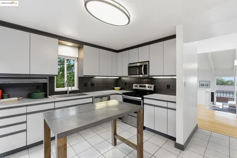 a kitchen with stainless steel appliances a stove a refrigerator and a microwave