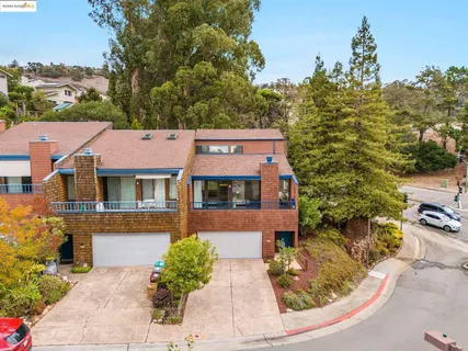 an aerial view of residential houses with outdoor space and trees