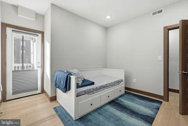a living room with a bed and dresser