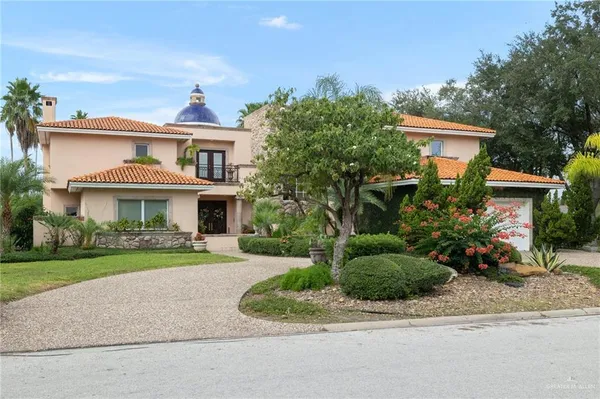 a front view of a house with a yard and potted plants
