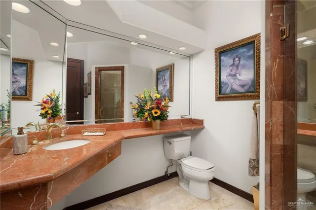 a bathroom with a toilet sink and mirror