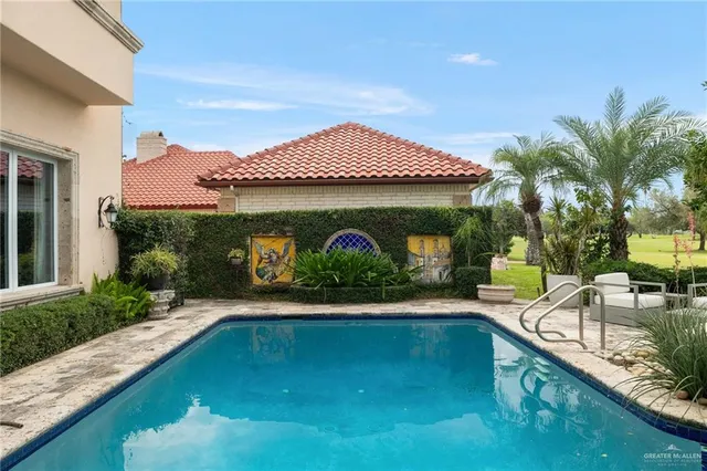 a view of a house with swimming pool and sitting area