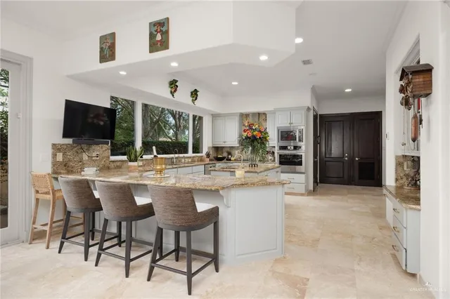 a kitchen with stainless steel appliances kitchen island granite countertop a sink and cabinets