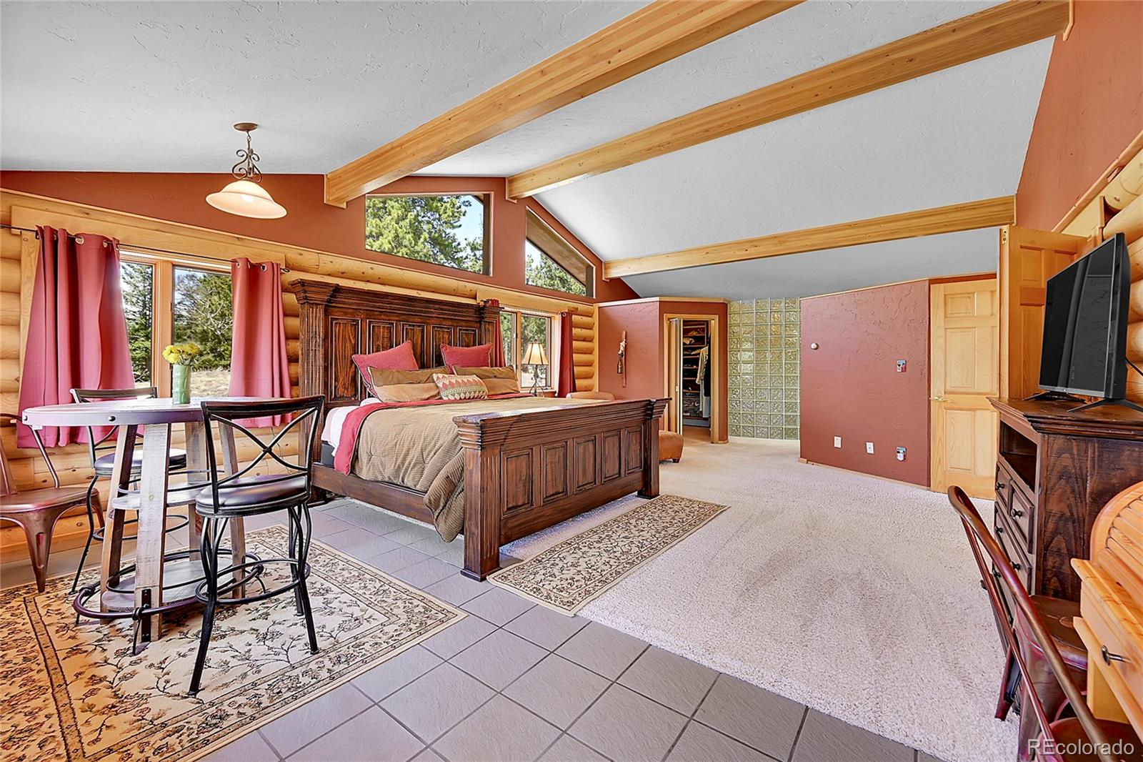 1392 Tapadero Road Bailey, CO 80421 - Photo 16 of 50 a bedroom with a bed a flat screen tv and a large window