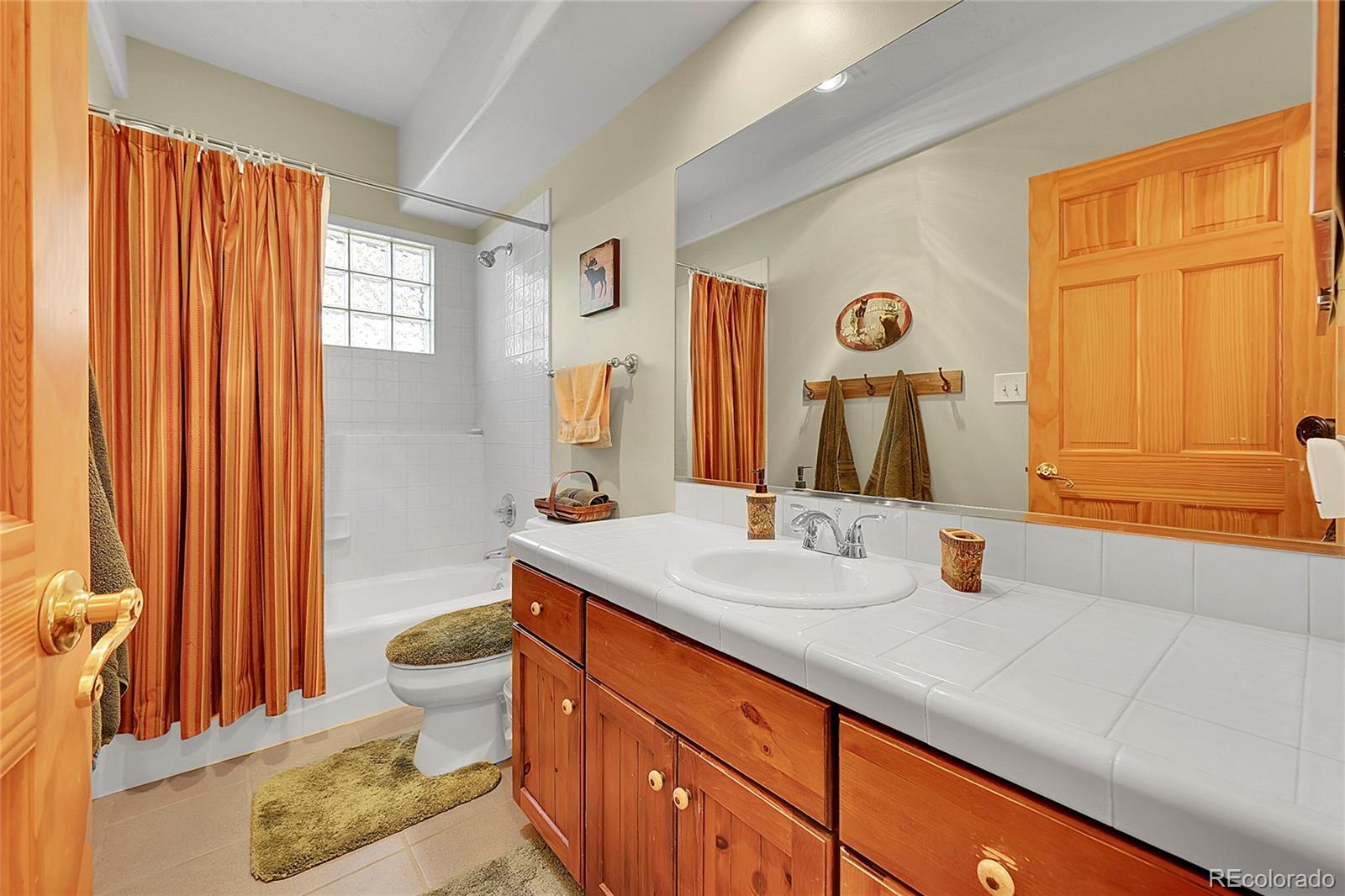 1392 Tapadero Road Bailey, CO 80421 - Photo 28 of 50 a bathroom with a granite countertop sink and a mirror