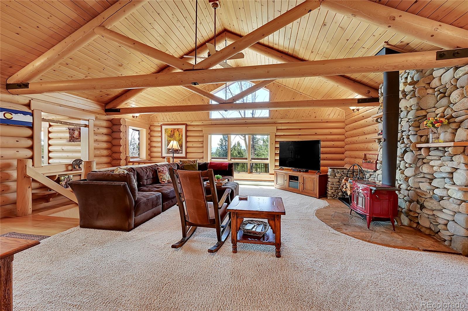 1392 Tapadero Road Bailey, CO 80421 - Photo 6 of 50 a living room with furniture a flat screen tv and a table