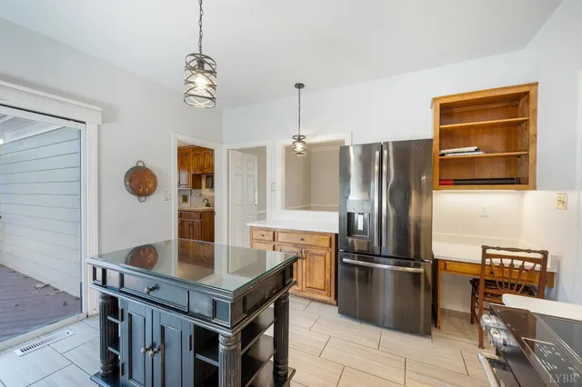 a view of an empty room with wooden floor fireplace and a window