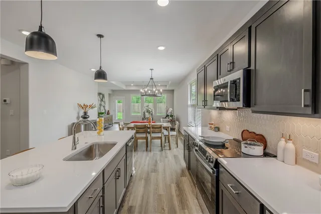 a kitchen with granite countertop a sink a counter top space stainless steel appliances and cabinets