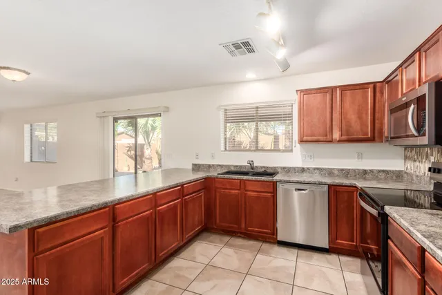 a kitchen with stainless steel appliances granite countertop a sink dishwasher stove and cabinets