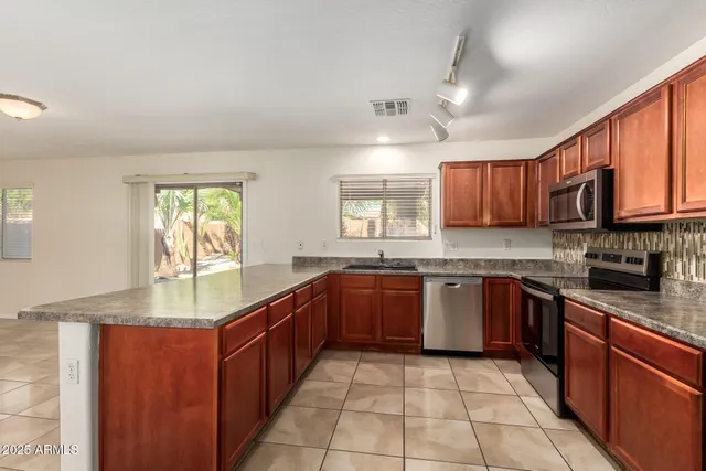 a large kitchen with granite countertop a stove sink and cabinets