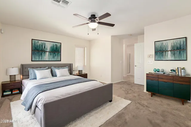 a spacious bedroom with a bed and a flat screen tv