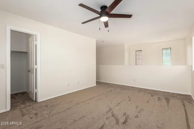 an empty room with a ceiling fan and a window
