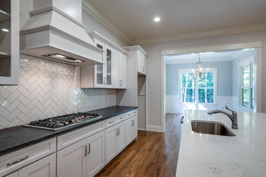 5908 Pinewood Road Franklin, TN 37064 - Photo 13 of 30 a kitchen with stainless steel appliances a sink a stove and white cabinets
