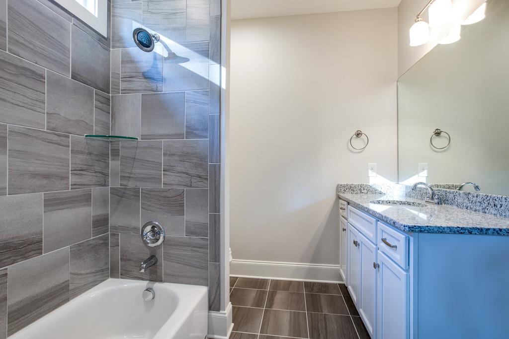 5908 Pinewood Road Franklin, TN 37064 - Photo 25 of 30 a bathroom with a granite countertop sink a toilet and shower