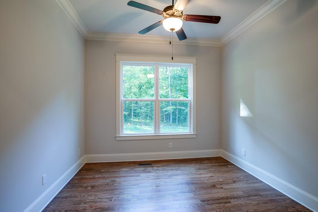 5908 Pinewood Road Franklin, TN 37064 - Photo 6 of 30 an empty room with wooden floor ceiling fan and windows