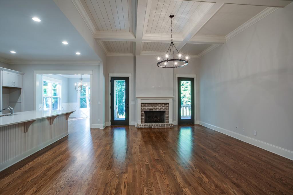 5908 Pinewood Road Franklin, TN 37064 - Photo 8 of 30 an empty room with wooden floor fireplace and chandelier