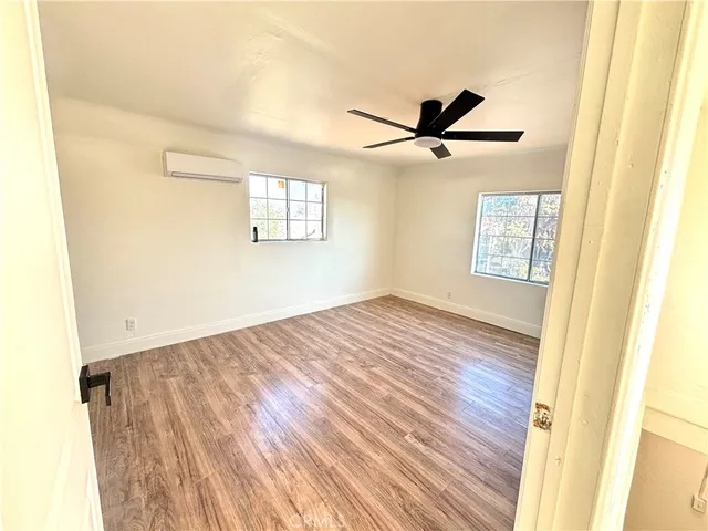 a view of a room with wooden floor and a ceiling fan