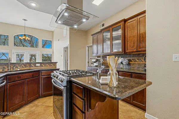 a kitchen with stainless steel appliances granite countertop a sink a stove and cabinets