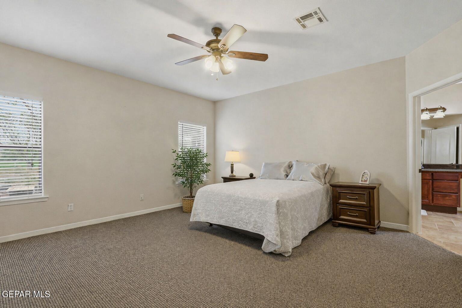 617 Wallace Road Anthony, NM 88021 - Photo 25 of 65 a spacious bedroom with a bed and a ceiling fan