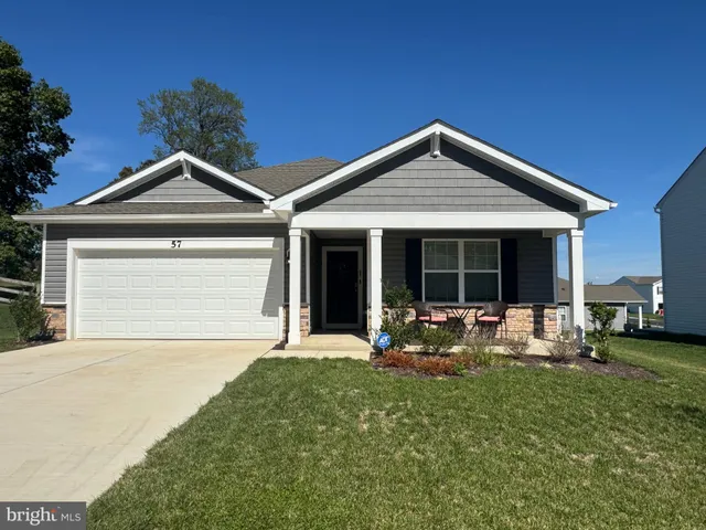 a front view of a house with a garden and yard