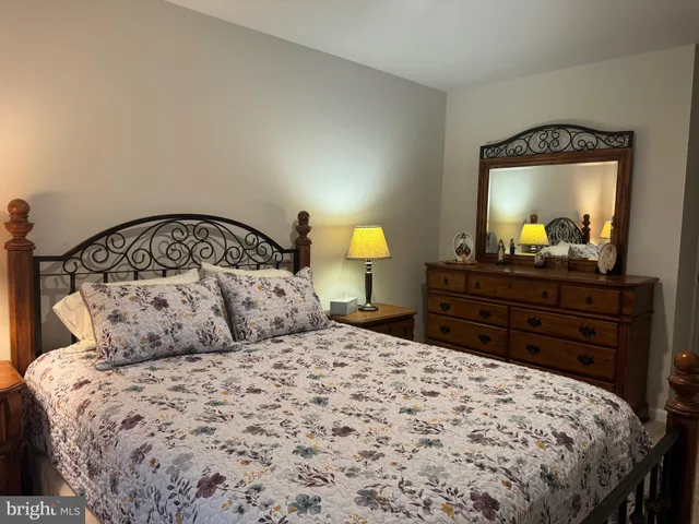 a bedroom with a bed and a mirror on dresser