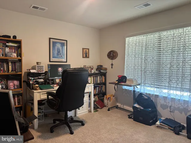 a view of a workspace with furniture and a window
