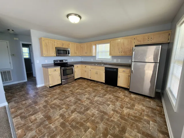 a kitchen with a refrigerator stove top oven and sink