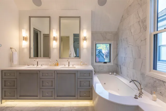 a bathroom with a granite countertop sink mirror and bathtub