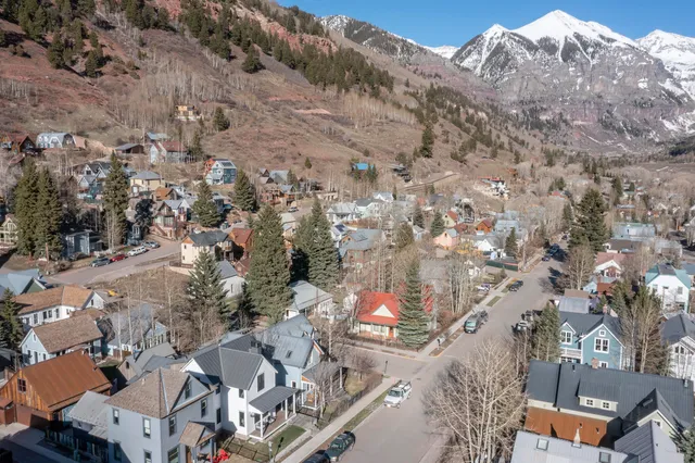 an aerial view of a house with a mountain