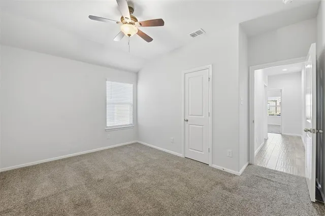 a view of an empty room and a ceiling fan window