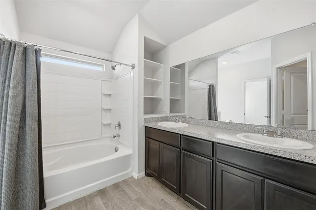 a bathroom with a granite countertop sink mirror bathtub and shower