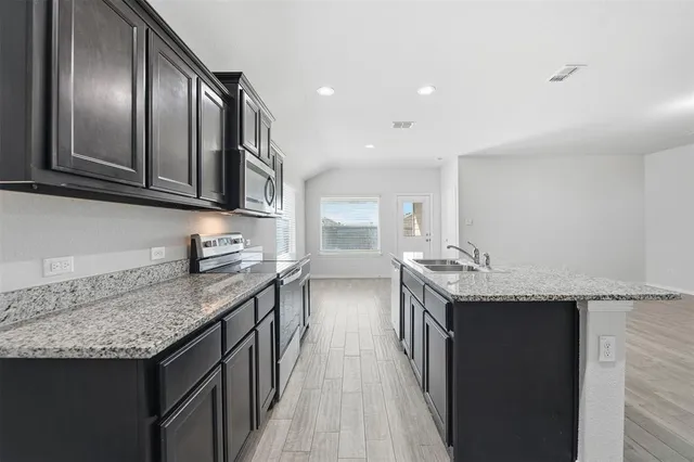a kitchen with granite countertop stainless steel appliances and wooden cabinets
