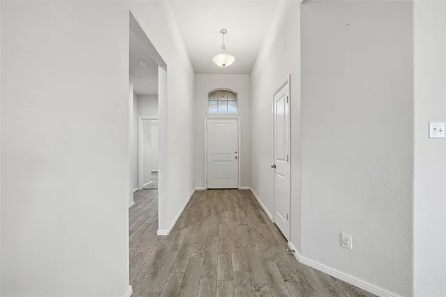 a view of a room with wooden floor and entryway
