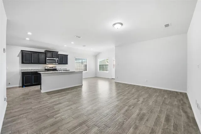 a large kitchen with cabinets wooden floor and stainless steel appliances