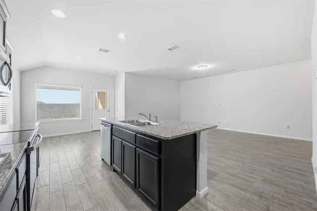 an empty room with wooden floor and window