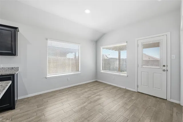 a view of an empty room with a window and fireplace