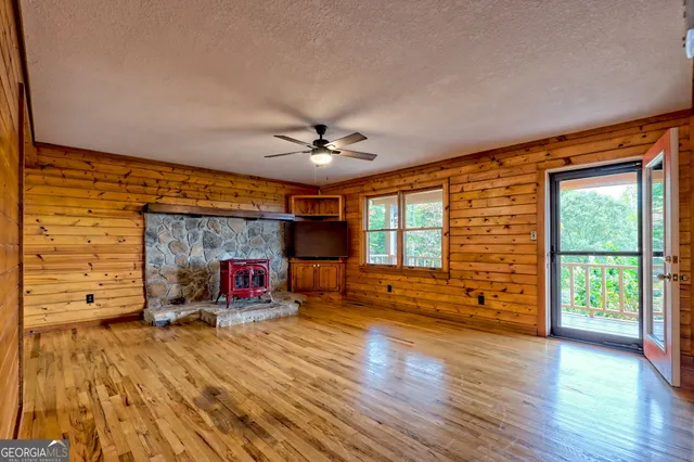 a living room with stainless steel appliances granite countertop furniture a fireplace and wooden floor
