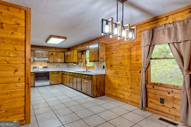 a large kitchen with stainless steel appliances granite countertop a sink and cabinets