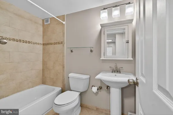 a bathroom with a sink toilet mirror and shower