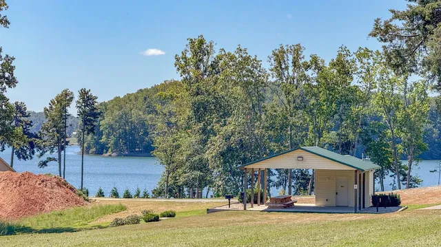 a sign board with a bench and trees around