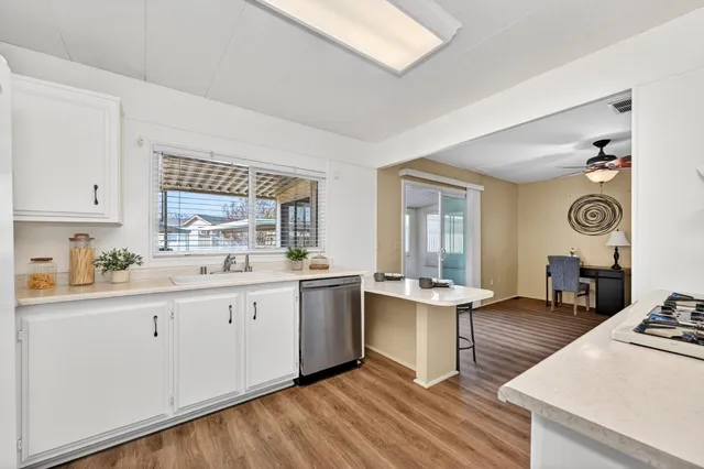 a kitchen with sink stove and wooden floor