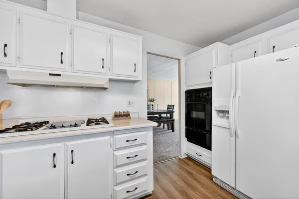 a kitchen with white cabinets and refrigerator