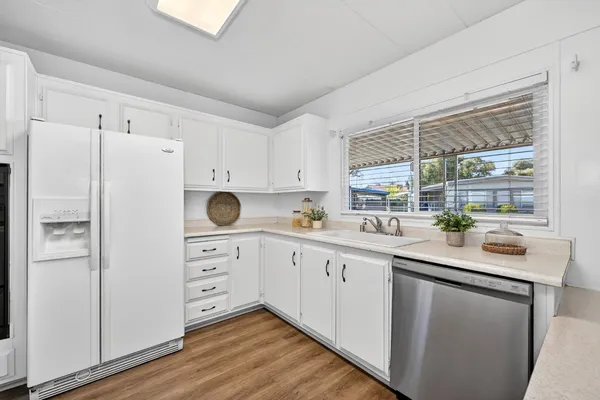 a kitchen with white cabinets and white appliances