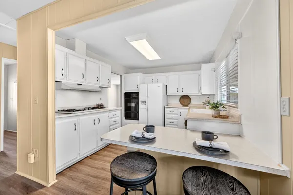 a kitchen with white cabinets and appliances